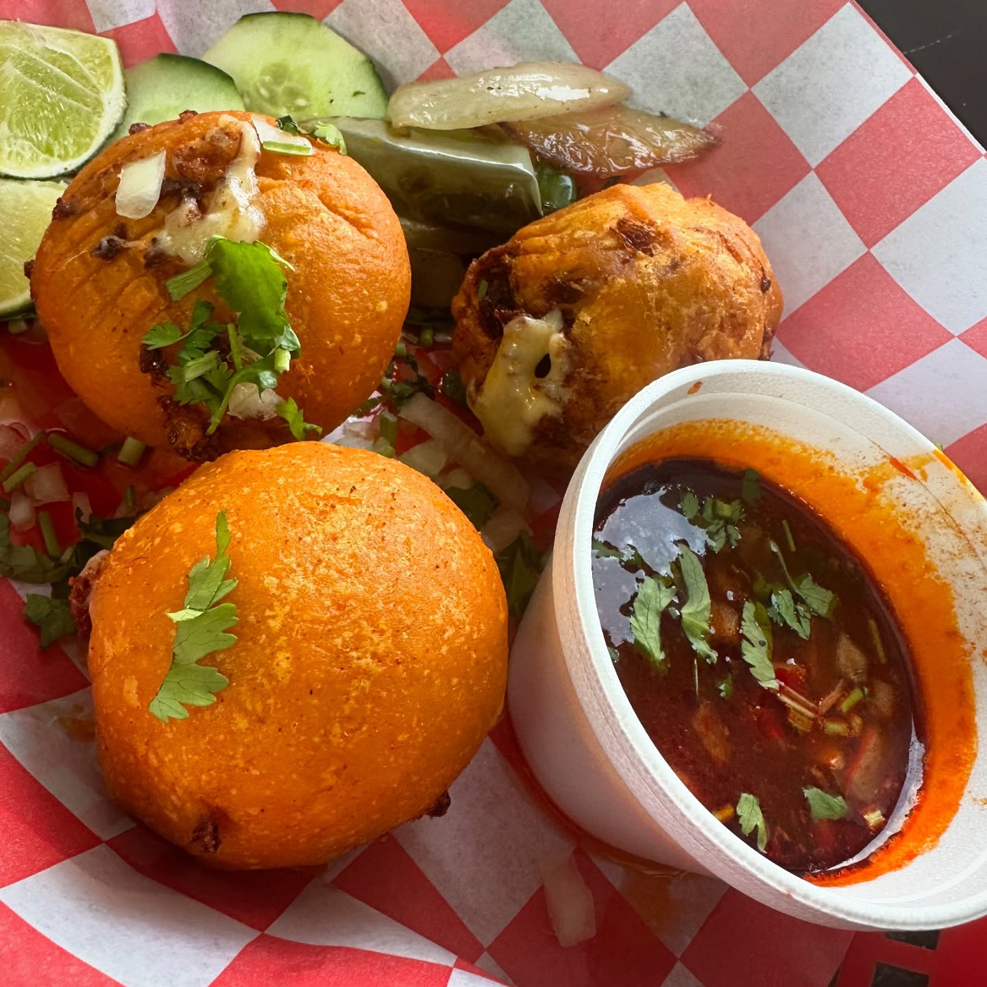 Golden birria cheese bombas served with a side of consommé